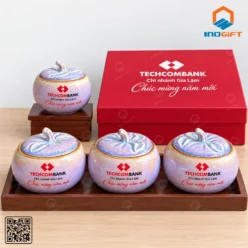 Bốn hũ đựng mứt dáng bí men tím hồng in logo Techcombank trên khay gỗ